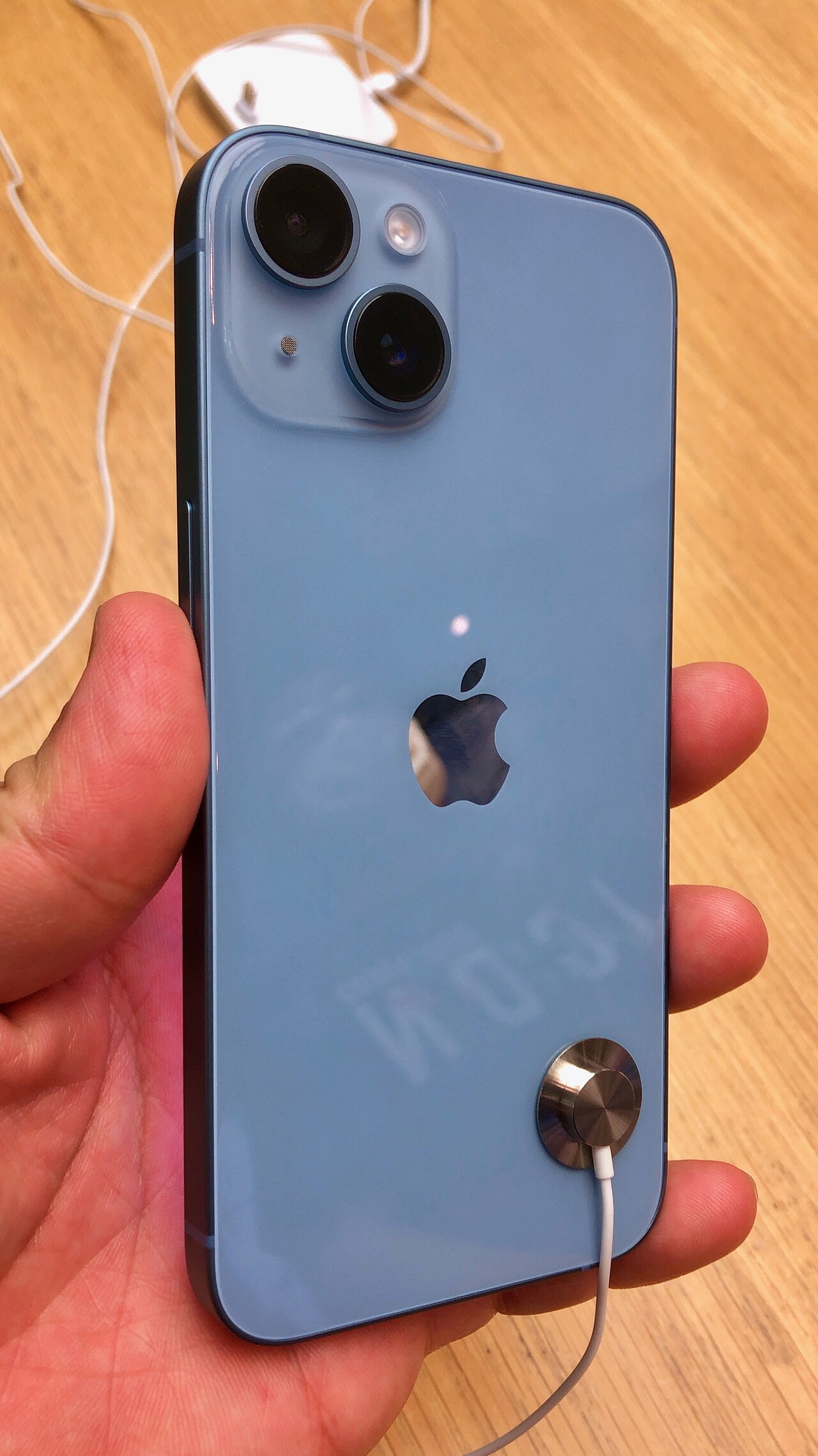 手に持った青いiPhone 14を背面から撮影した写真。紹介する出品は別色のスターライト・128GBの整備済み品です。出品個体の写真ではありません。