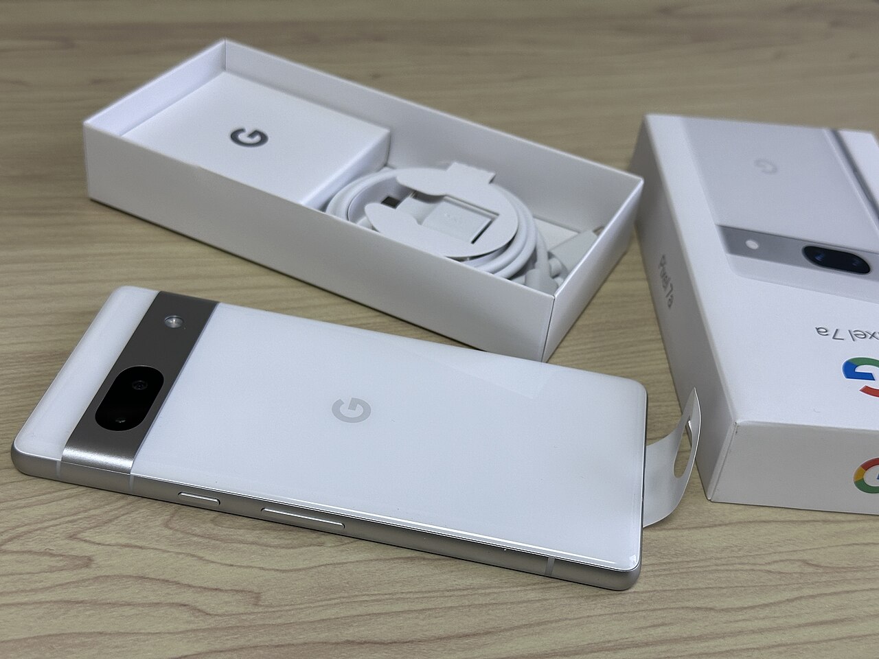 Snow色のGoogle Pixel 7aの背面と箱の外観参考写真。紹介はG82U8・128GB・Snow。出品個体ではなく、写真の箱・ケーブルが付属するとは限りません。写真の地域型番は未確認。 写真：Tatsuo Yamashita／CC BY 2.0。独自加工なし。